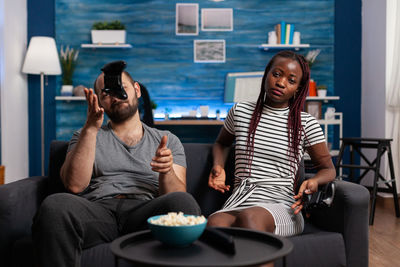 Young couple sitting on sofa at home