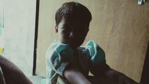 Close-up of boy sitting at home