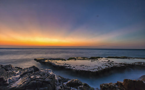 Scenic view of sea against sky at sunset