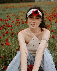 Portrait of young woman sitting on field