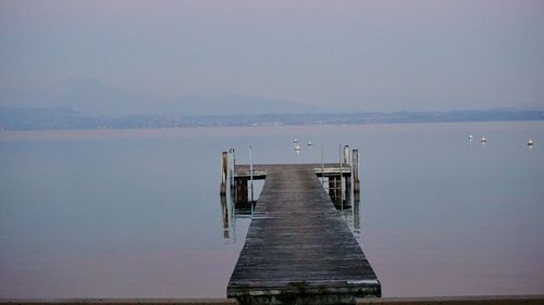 Pier over lake against sky