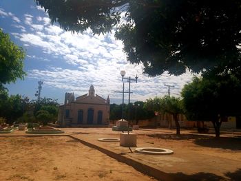 Houses by street and buildings against sky