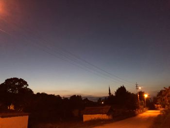 Silhouette trees against clear sky at sunset