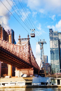 Low angle view of bridge over city against sky