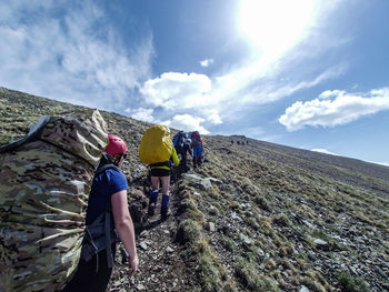 Rear view of men on mountain against sky