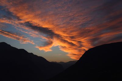 Scenic view of silhouette mountains against orange sky