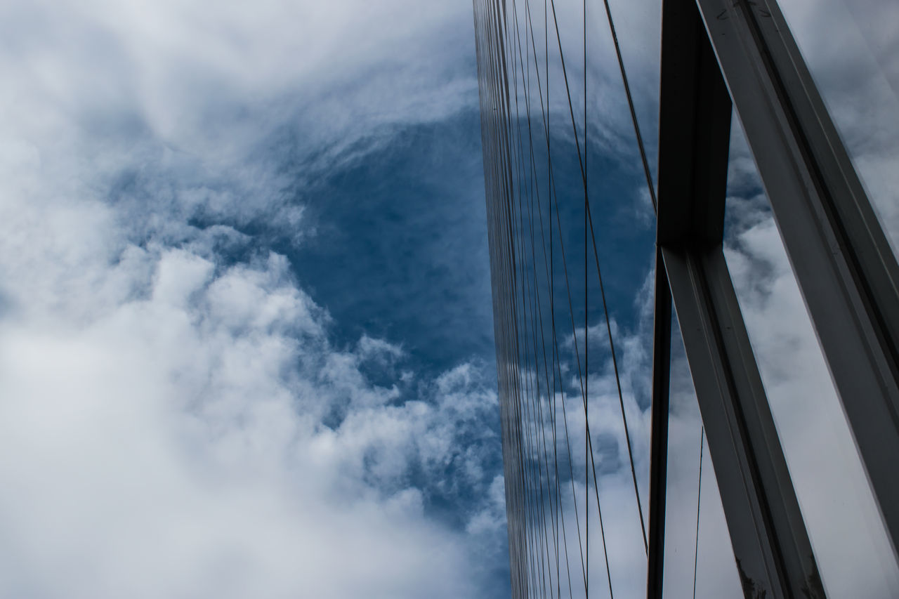 LOW ANGLE VIEW OF SUSPENSION BRIDGE CABLES AGAINST CLOUDY SKY