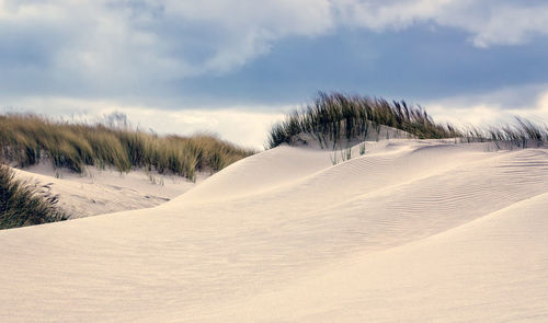 Scenic view of snow covered land against sky