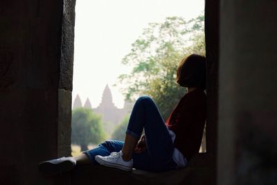 Side view of young woman relaxing at window