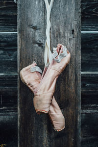 Ballet shoes hanging from wooden wall