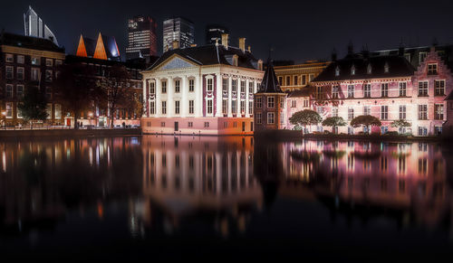 Reflection of illuminated buildings in river at night