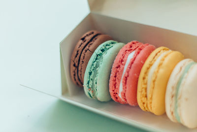High angle view of fresh macaroons in box on table
