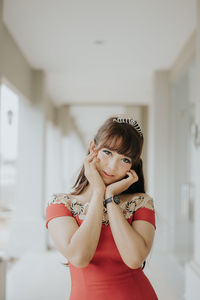 Portrait of young woman standing at home