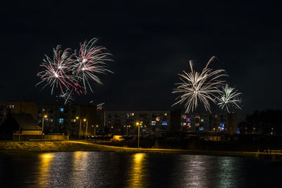 Firework display over river at night