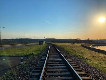 Railroad tracks against sky during sunset