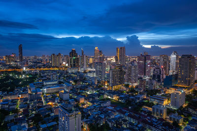 Illuminated modern buildings in city against sky