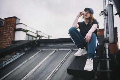 Portrait of young woman sitting on rooftop