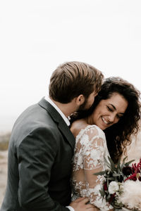 Young couple kissing against white background