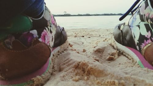 Close-up of shoes on beach