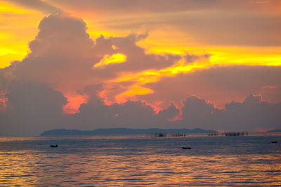 Scenic view of sea against dramatic sky during sunset