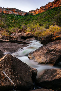 Scenic view of river stream amidst rocks