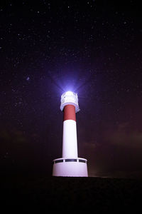 Low angle view of lighthouse against sky at night