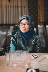 Smiling teenage girl sitting at restaurant