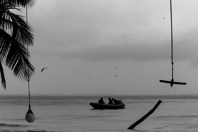 View of birds and fishermen over sea against sky