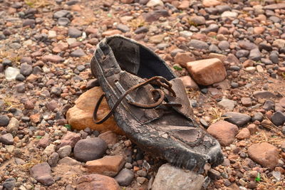 Close-up of old weathered shoe on stones