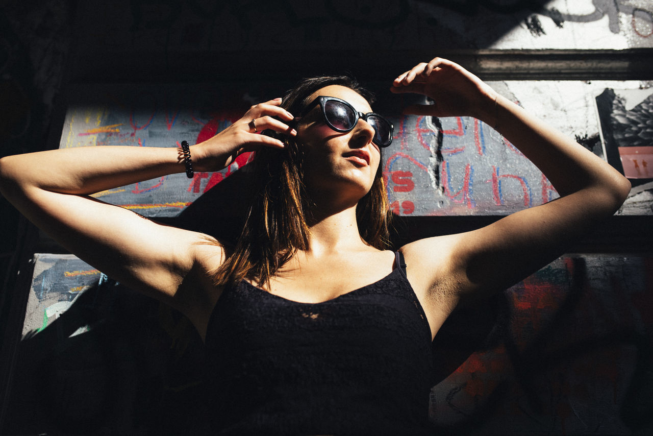 adult, fashion, women, one person, black, young adult, glasses, sunglasses, photo shoot, portrait, lifestyles, performance art, indoors, stage, person, singing, arm, arts culture and entertainment, front view, clothing, hairstyle, music, performance, leisure activity, arms raised, waist up, cool attitude, human face, eyewear, female, limb