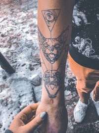 Close-up of woman holding hand of man with tattoo