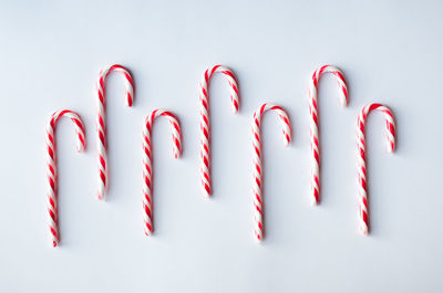 Candy canes arranged in a row on a plain white background.