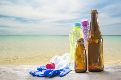 Close-up of bottles and glove at beach