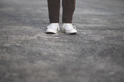 Low section of man standing on road