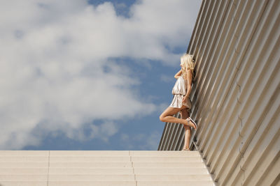 Low angle view of woman standing against sky