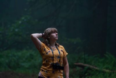 Young woman looking away in forest