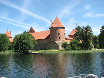 View of trees by river against building