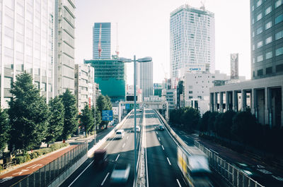 Vehicles on road in city against clear sky