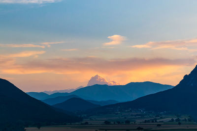Scenic view of snowcapped mountains against sky during sunset