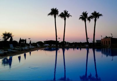 Reflection of trees in water at sunset