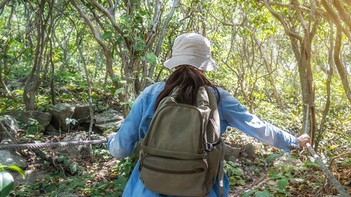 Rear view of woman standing in forest