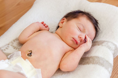 High angle view of baby girl sleeping on blanket at home