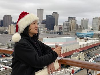 Woman wearing santa hat while standing in city
