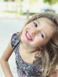 Close-up portrait of smiling girl standing on road