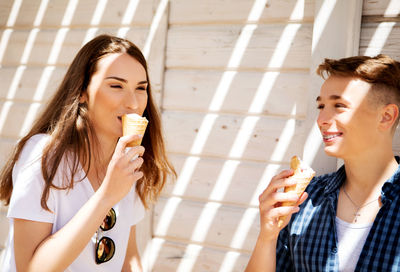 Portrait of a smiling young woman eating ice cream