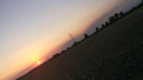 Silhouette man on field against sky during sunset