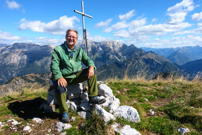 Full length of mature man sitting on mountain