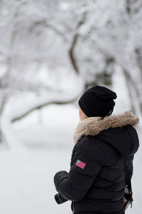 Rear view of man and woman standing on snow