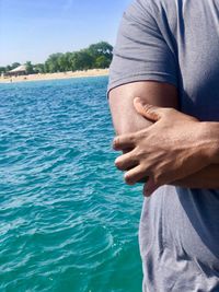 Midsection of man holding hands in sea