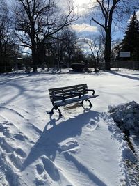 Empty bench in park during winter
